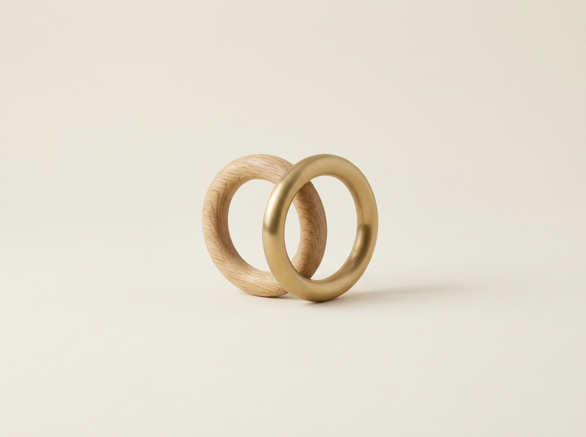 Dos anillos entrelazados, uno de madera y otro de latón.